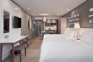 德班德班乌兰加万豪Protea酒店的酒店客房设有一张大床和一张书桌。