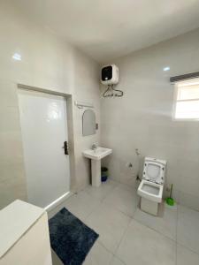 阿布贾Cozy And Serene Studio Apartment的白色的浴室设有卫生间和水槽。