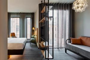 华沙Moxy Warsaw Praga的酒店客房带一张床,房间带一张床,还有起居室。