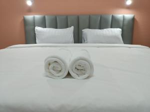 佛丕โรงแรม เดอะพีช / The Peach hotel的一张带两条毛巾的白色床