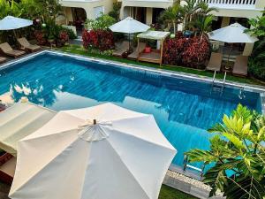 会安Hoian Village Lodge的游泳池旁的白色遮阳伞
