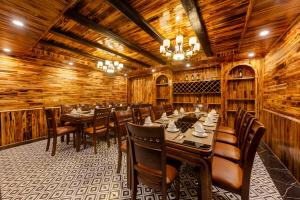 萨帕Sapa Soleil Hotel的用餐室设有木墙和桌椅