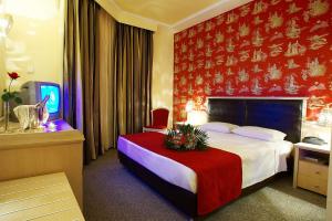 塞尔米艾瑞斯酒店的酒店客房,设有一张红色墙壁的床