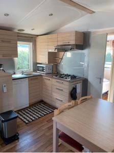 加桑Mobil-home 4 personnes - Camping Montana, golfe de Saint-Tropez的厨房配有桌子和炉灶。 顶部烤箱