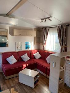 加桑Mobil-home 4 personnes - Camping Montana, golfe de Saint-Tropez的客厅配有红色的沙发和桌子