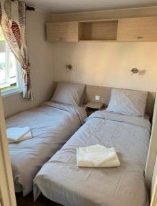 加桑Mobil-home 4 personnes - Camping Montana, golfe de Saint-Tropez的两张睡床彼此相邻,位于一个房间里