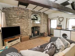 米德尔赫姆In & Out Cottage的带沙发和石制壁炉的客厅