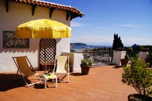 伊斯基亚唐·佩德罗酒店的庭院配有椅子和黄色雨伞