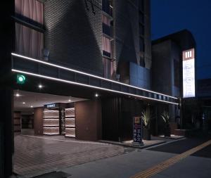 名古屋M'z HOTEL的前面有绿色交通灯的建筑