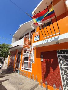 纳斯卡Marlon's House Nasca的一座橙色和白色的建筑,上面有旗帜