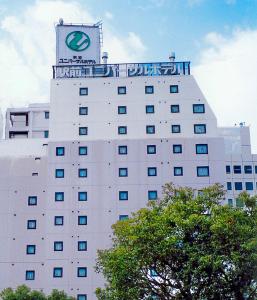 冈山Okayama Ekimae Universal Hotel的顶部有钟的建筑