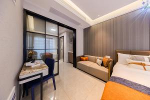 深圳玺客行政公寓酒店（深圳福田会展中心店）的一间卧室配有一张床、一张桌子和一张沙发