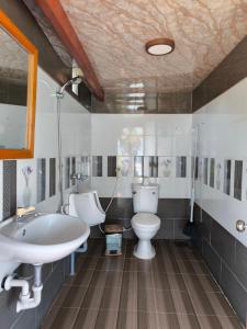 绥和市Kaktus home & kafe的浴室配有盥洗盆、卫生间和浴缸。