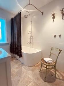 黑荒地拉兰吉精品度假屋的带浴缸和椅子的浴室