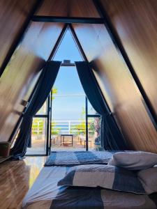 绥和市Kaktus home & kafe的帐篷内的卧室设有大窗户