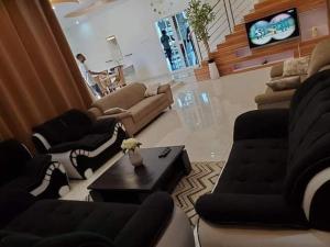 科托努Villa duplex meublée piscine à Akpakpa ciné concorde的带沙发、沙发和桌子的客厅