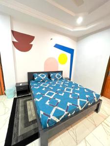 瓦加杜古F.S service的一间卧室配有一张带蓝色棉被的床