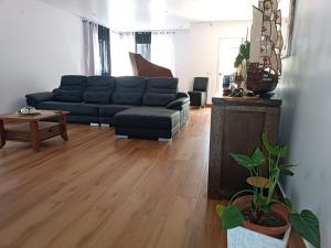 普拉亚Residência Águia的客厅设有黑色沙发和木地板