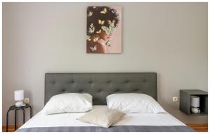 普利莫顿M&Z Apartmani的卧室配有一张床,墙上挂有绘画作品