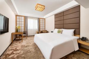 上海上海粤海酒店 的卧室配有一张白色大床和电视。