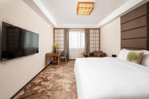上海上海粤海酒店 的酒店客房,配有床和电视