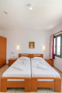 提诺斯Ageri Hotel的白色墙壁客房的两张床