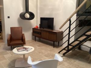 拉西约塔LOFT AUTHENTIQUE 3 STARS Terrasse VIEUX PORT的客厅配有电视、椅子和桌子
