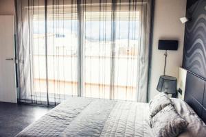 圣马特奥Apartamento con estilo y acogedor的一间卧室设有一张床和一个大窗户
