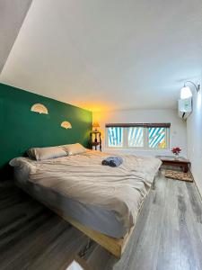 河内Hoan Kiem House的一张大床,位于一个绿色的墙壁内