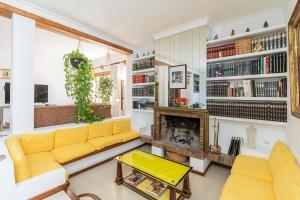 马贝拉Casa El Maizal的客厅设有黄色沙发和壁炉