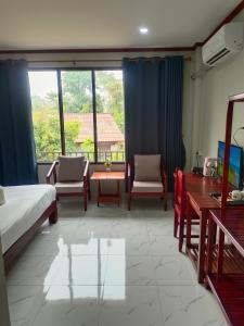 万荣Dokchampa Hotel的卧室配有一张床和一张桌子及椅子
