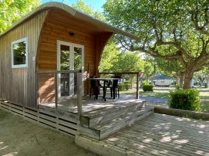 萨拉瓦International Camping Ardèche的甲板上的小小屋,配有桌子