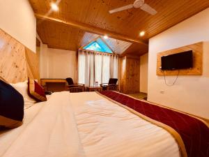 马拉里Manali Castle - Wonder Hill的配有电视的客房内的一张大床