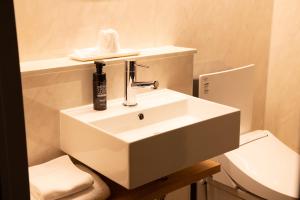 东京浅草指月日式旅馆的白色的浴室设有水槽和卫生间。