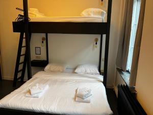 那慕尔BED Pepin的两张双层床,配有白色的床单和毛巾
