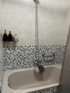 维戈Disfruta de Exclusiva habitación privada, A 5 minutos de la playa en Vigo的浴室铺有黑色和白色瓷砖,配有浴缸。