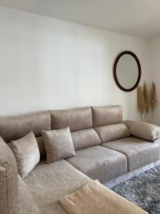 维戈Disfruta de Exclusiva habitación privada, A 5 minutos de la playa en Vigo的客厅里一张带镜子的棕色沙发