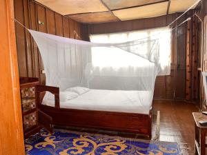 GanviéHotel Germain - Ganvié Holiday Resort的一间卧室配有一张带蚊帐的床