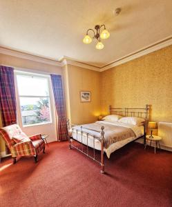 埃尔金The Pines Guest House的卧室配有床、椅子和窗户。