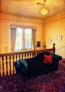 埃尔金The Pines Guest House的客厅的窗户前设有沙发