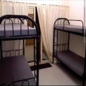 迪拜Backpackers Hostel的带窗户的客房内的两张双层床