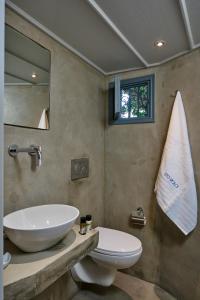 波罗斯Sto Roloi Island Houses的一间带水槽、卫生间和镜子的浴室
