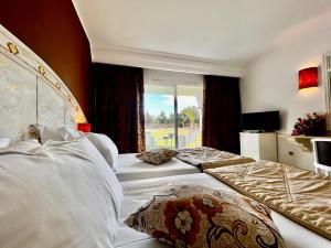 古莱比耶Cap Bon Kelibia Beach Hotel & Spa的酒店客房设有两张床和窗户。
