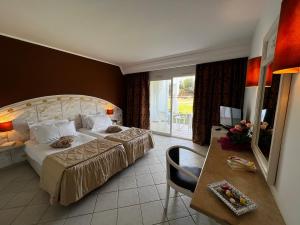 古莱比耶Cap Bon Kelibia Beach Hotel & Spa的酒店客房配有一张床铺和一张桌子。