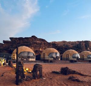 瓦迪拉姆Revan Rum Luxury Camp的沙漠中一群岩石的圆顶