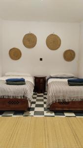 丹吉尔Dar Gara的一间卧室设有两张床,铺有一个 ⁇ 板地板