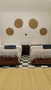 丹吉尔Dar Gara的一间卧室设有两张床,铺有一个 ⁇ 板地板