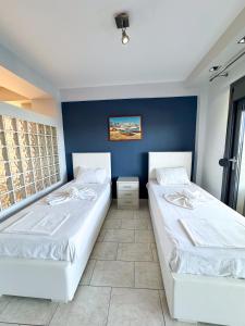 帕拉利亚卡泰里尼斯Aqua Mare Luxury Apartments的蓝色墙壁客房的两张床