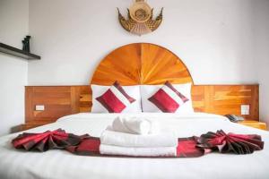 武里南Sky View Hotel Buriram的一张床上有红色和白色的毛巾