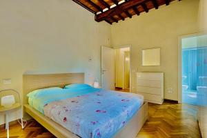 LibbianoBorgo di Libbiano的一间卧室配有一张带蓝色棉被的大床